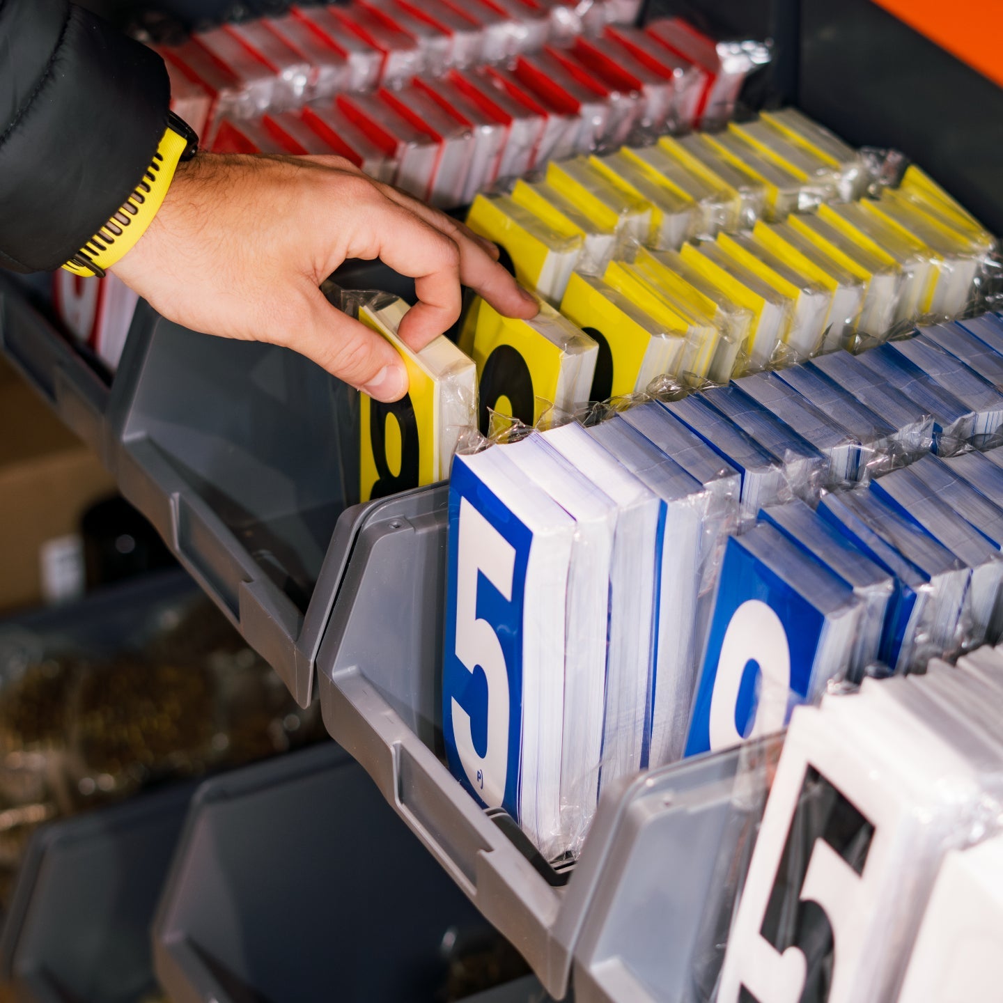 Hand selecting a numbered part from a tool chest with labeled drawers.